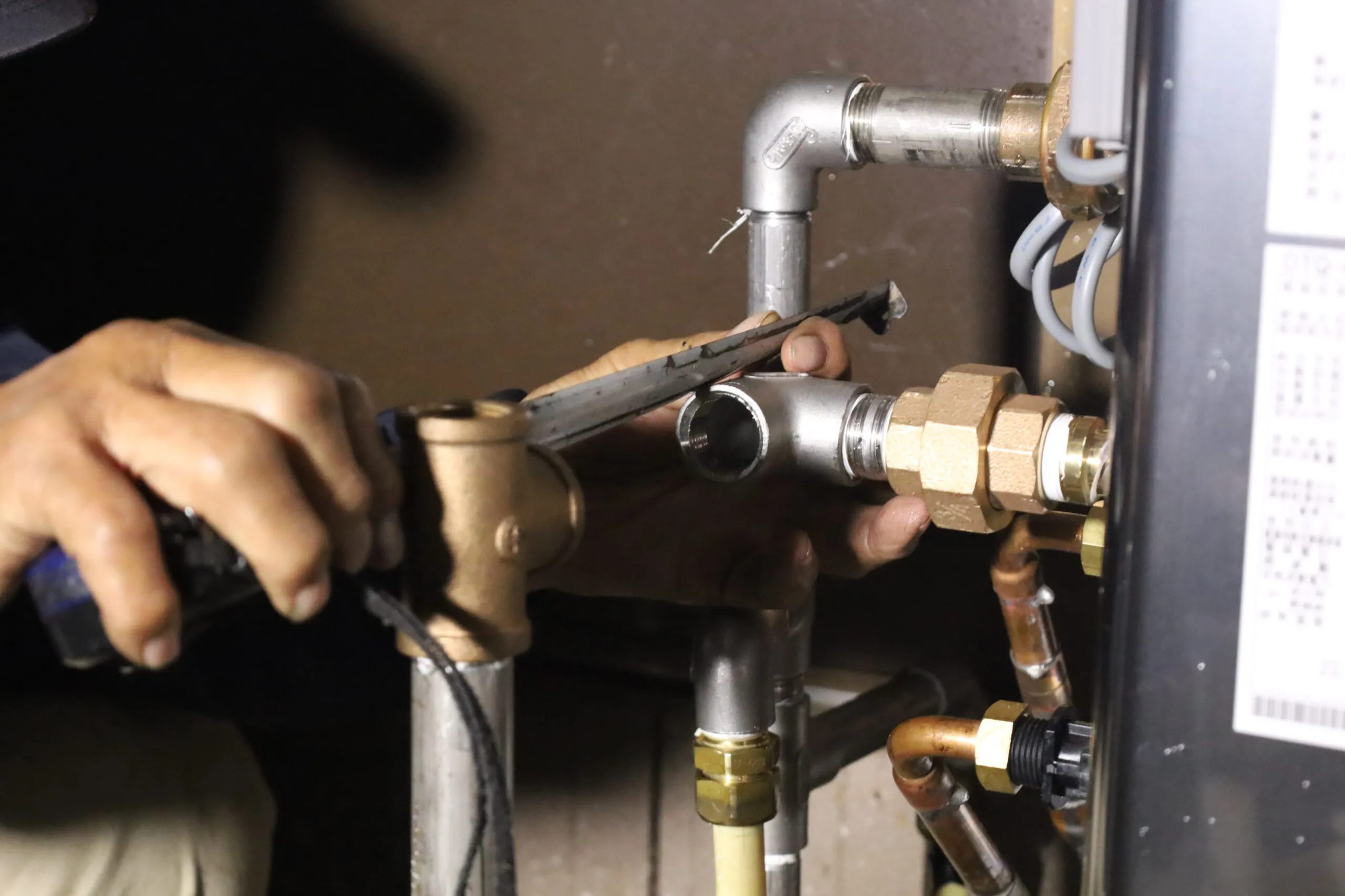 給排水管の継手を工具で締めている手元